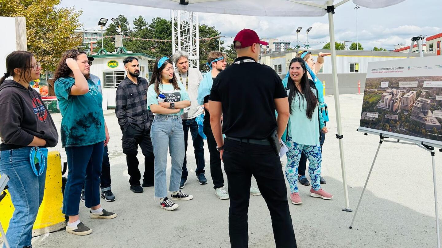 Clayton Wong (centre) speaks to a group of Science World staff about progress on the new hospital
